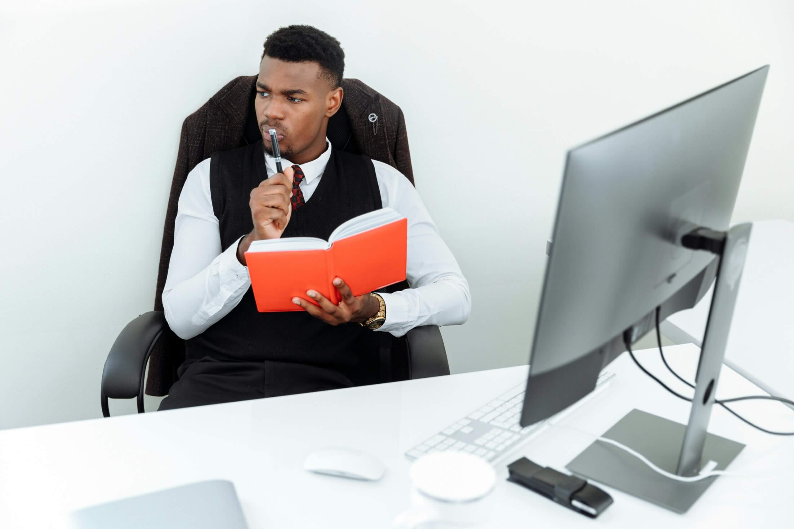 Employee reflecting with a notebook at his desk