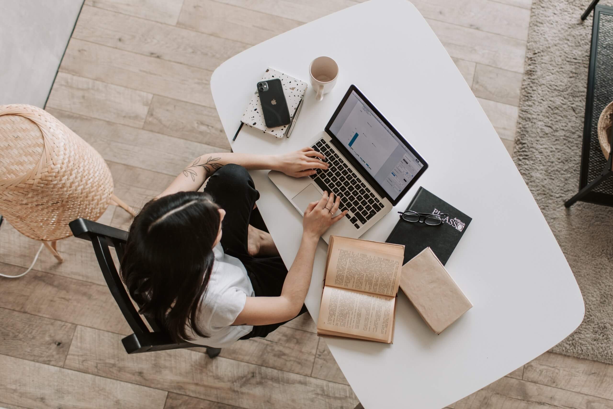 woman at desk with computer and note pad