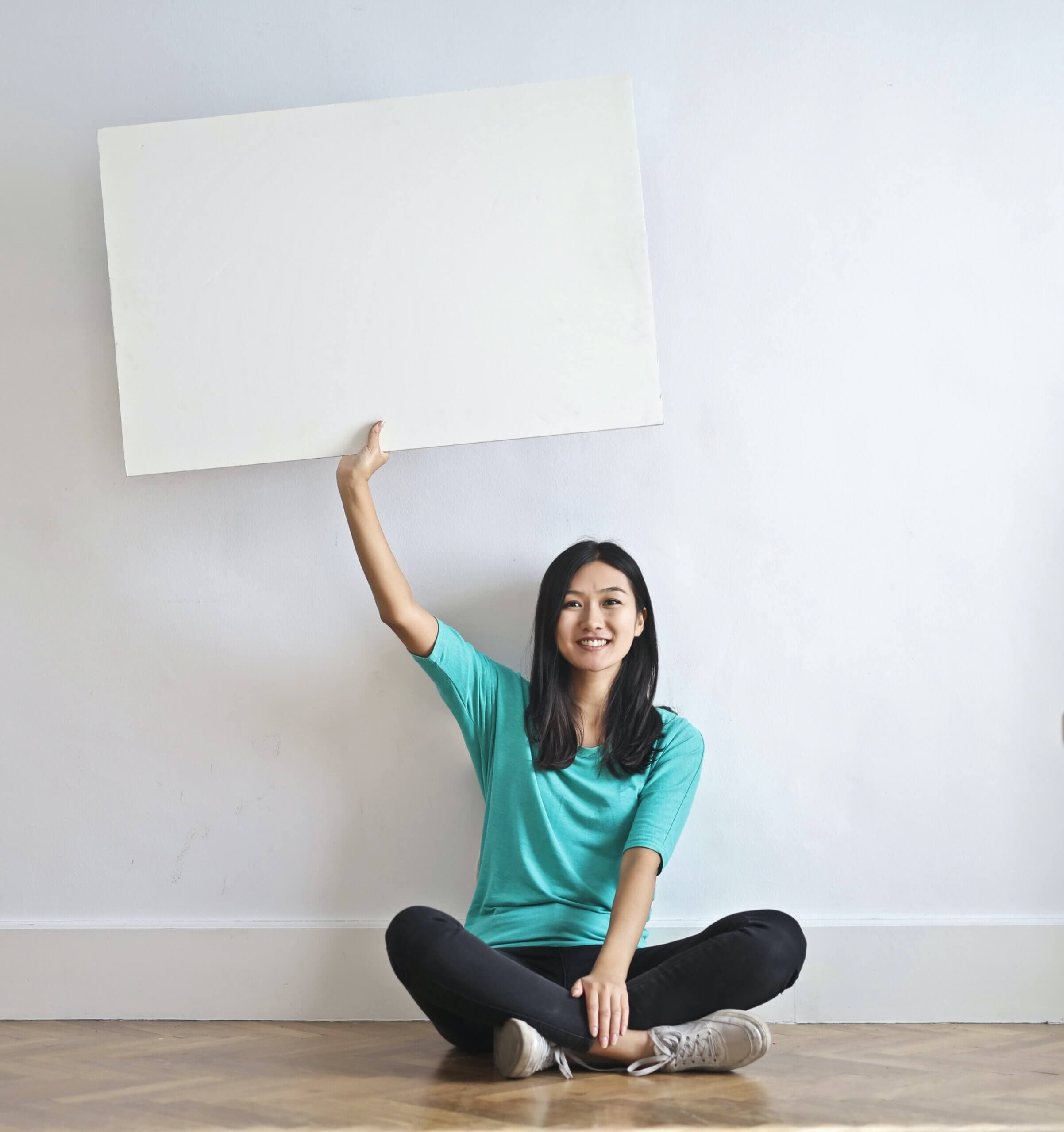 Woman holding a blank piece of paper