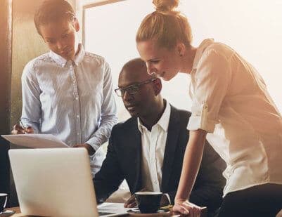 Diverse team collaborating around a laptop