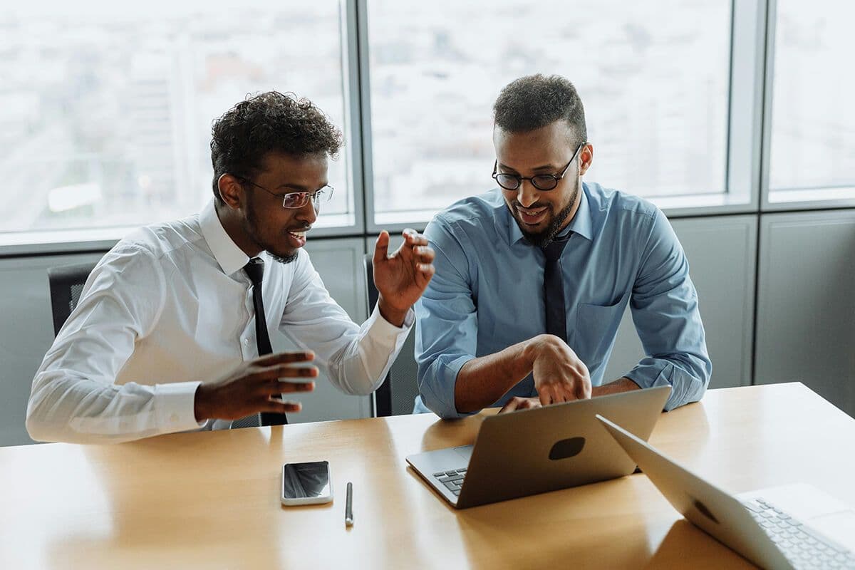 Two colleagues collaborating over a laptop